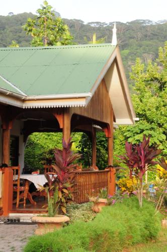 a small house with a green roof and a table at Casa De Leela Self Catering Guest House in La Digue
