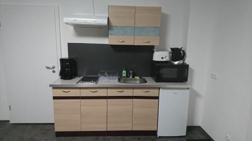 a small kitchen with a sink and a microwave at kleine Fewo Peter in Bärenstein in Bärenstein