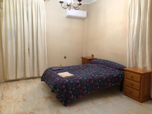 a small bedroom with a bed and a dresser at PISO ROCIO in Almonte