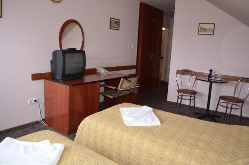 a hotel room with two beds and a tv on a table at Pension Tip-Top in Târgu-Mureş