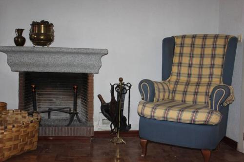 - un salon avec une chaise et une cheminée dans l'établissement Apto. Rural Las Candelas. La Covatilla, à Candelario