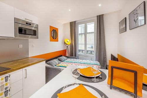 Il comprend une cuisine et un salon avec une table. dans l'établissement CLIMATISATION-Hypercentre-PARKING-COSY CARNOT-AVIGNONSMILE, à Avignon