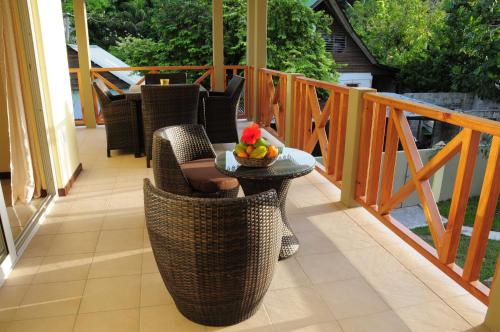 a balcony with a table with a bowl of fruit on it at Casa De Leela Self Catering Guest House in La Digue