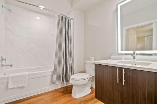 a bathroom with a toilet and a sink and a tub at Global Luxury Suites at Downtown Mountain View in Mountain View