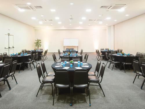 a room with rows of tables and chairs in it at Vinhedo Plaza Hotel in Vinhedo