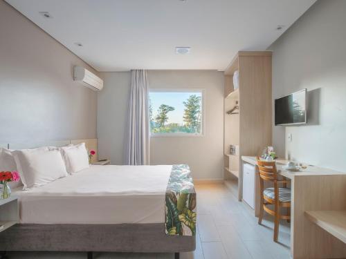 a hotel room with a bed and a kitchen at Valinhos Plaza Hotel in Valinhos