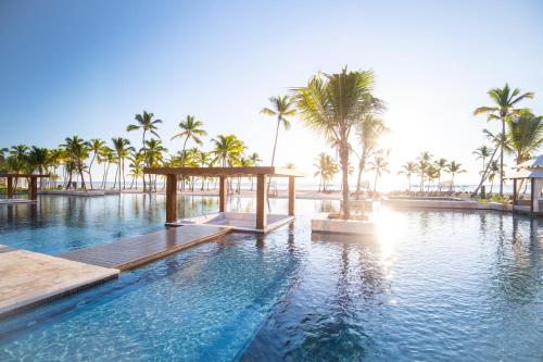 a swimming pool with palm trees and a resort at Hyatt Zilara Cap Cana - Adults Only in Punta Cana