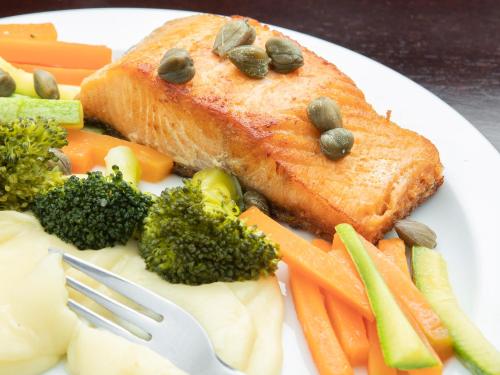 a plate of food with fish and vegetables with a fork at Valinhos Plaza Hotel in Valinhos