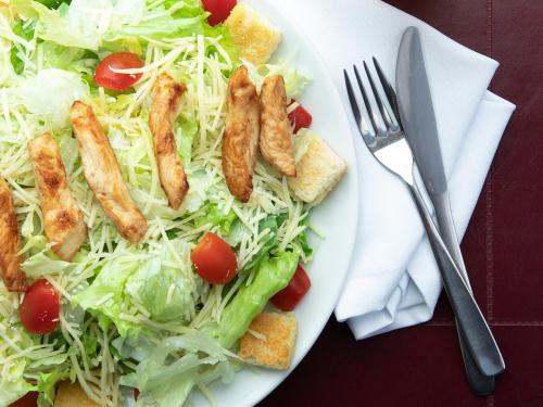a white plate with a salad with sausage and tomatoes at Valinhos Plaza Hotel in Valinhos