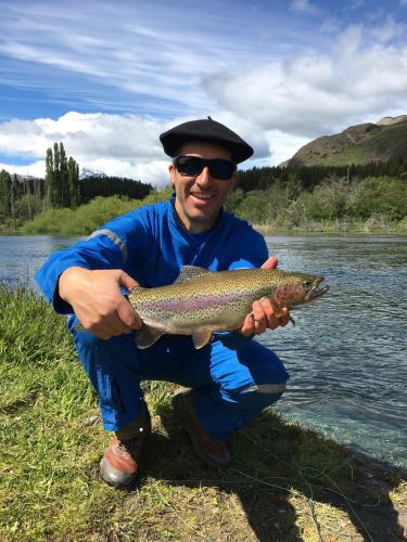 a man holding a fish in a river at Ribera Cochrane, Cochrane in Cochrane