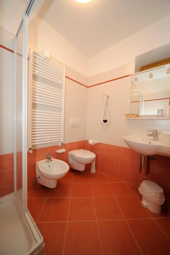 a bathroom with two toilets and a sink and a shower at Hotel La Nuova Montanina in Auronzo di Cadore