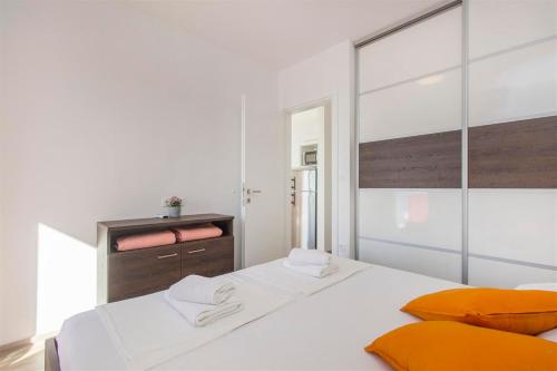 1 dormitorio blanco con 1 cama blanca grande con almohadas de color naranja en Villa top of Murter, one bedroom apartment 2, en Murter