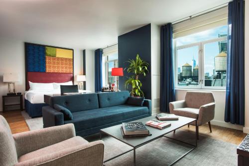 a living room filled with furniture and a large window at Hotel Hayden New York in New York