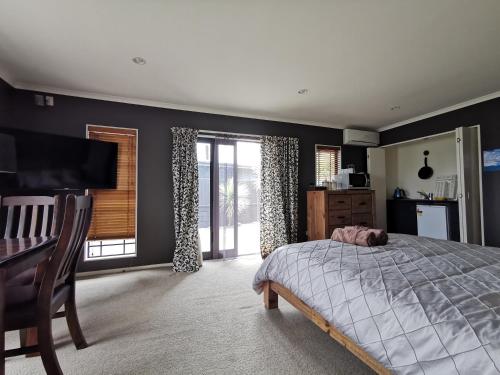 a bedroom with a bed and a desk and window at Lakeview Holiday Hideaway in Taupo