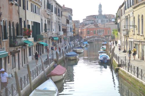 a group of boats in a canal in a city at Hotel Locanda Salieri in Venice