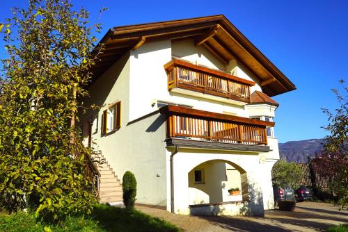 a small white building with a balcony on it at Unterbi Apartments in Appiano sulla Strada del Vino