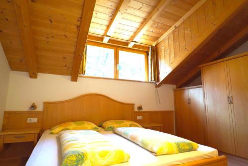 a bedroom with a bed with two pillows on it at Unterbi Apartments in Appiano sulla Strada del Vino