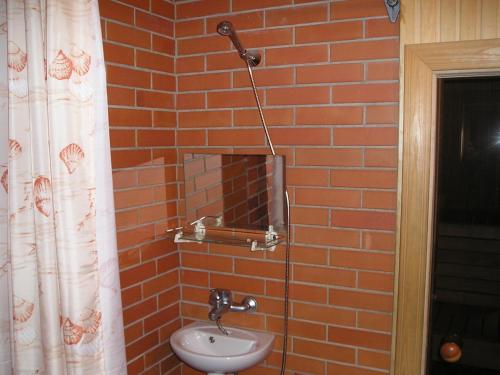a bathroom with a sink and a brick wall at Lõõdla Holiday House in Lümatu