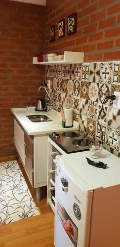a small kitchen with a stove and a refrigerator at Casa 24 Puerto Iguazu in Puerto Iguazú