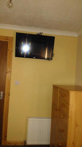 a television on a wall with a person taking a picture at Granville Guest House in Dyce