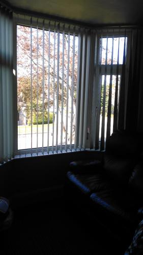 a dark room with two large windows and a couch at Granville Guest House in Dyce