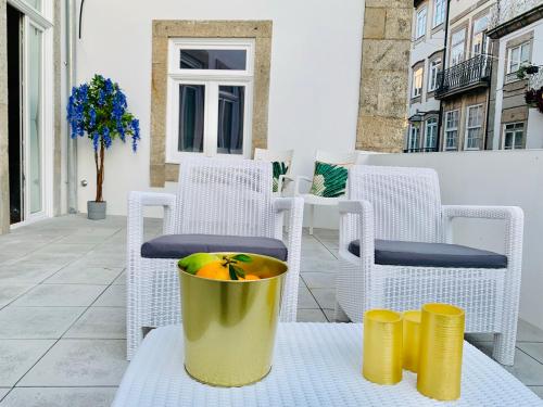 a yellow bucket sitting on a table with chairs at The Arch - Charming Apartments in the Historic Center in Braga