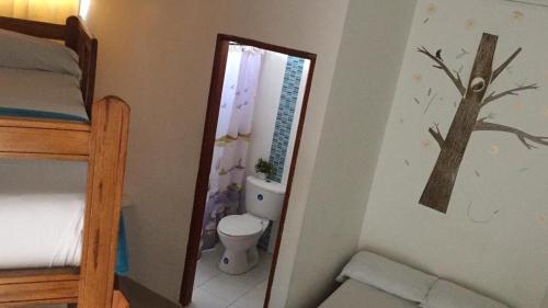 a bedroom with a toilet and a tree mural on the wall at Hotel Monaco De Riohacha in Ríohacha