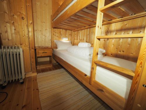 a room with a bed in a wooden cabin at Eggum Fishermans Cabin in Bøstad