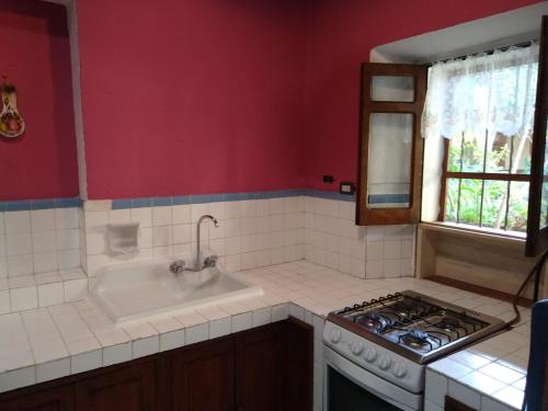 a kitchen with a stove top oven next to a sink at Casa Relox 23 in San Miguel de Allende
