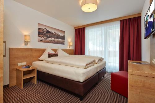 a hotel room with a bed and a television at SöldenLiving Appartements in Sölden