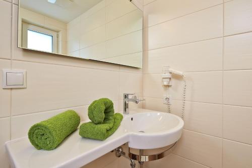 y baño con lavabo blanco y espejo. en SöldenLiving Appartements, en Sölden
