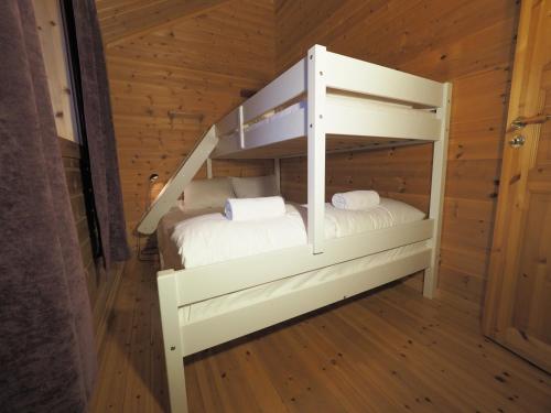 Ce lit superposé se trouve dans un dortoir doté de parquet. dans l'établissement Eggum Rorbuer, à Bøstad