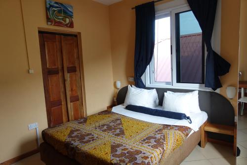 a bedroom with a bed with a large window at Cheers Guesthouse in Botianaw