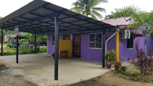 a purple and yellow house with a black roof at Homestay Che Kiah in Kuantan