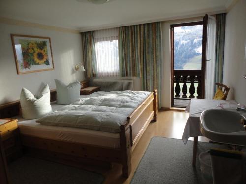1 dormitorio con cama grande y ventana grande en Spielbichlhof, en Mittersill