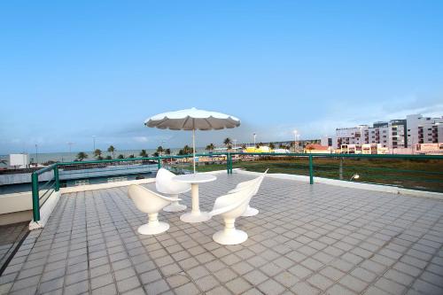 若昂佩索阿的住宿－Pousada Boi Bumbá Praia，屋顶上的桌椅和雨伞