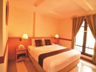 a bedroom with a large bed and a window at The Ecotel Bangkok in Bangkok