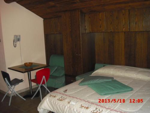 Schlafzimmer mit einem Bett, einem Tisch und Stühlen in der Unterkunft Lauson in Cogne