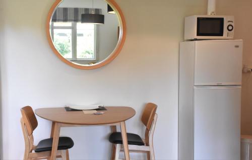 a kitchen with a table and a mirror and a refrigerator at Shy Cottage and Studio in Greytown