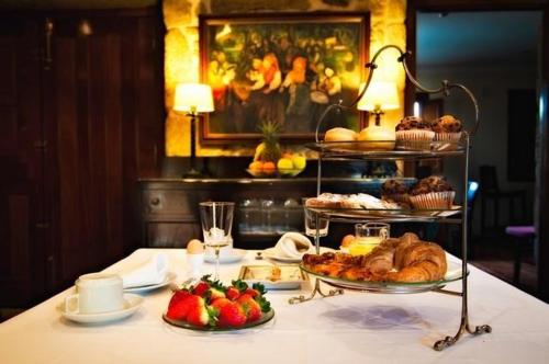 uma mesa coberta com comida e bolos sobre uma mesa em Pazo a Capitana em Cambados