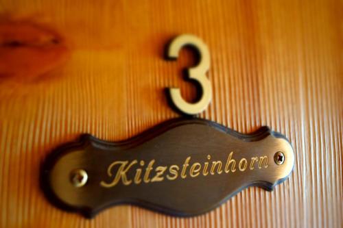 a black sign with the number three on a wall at Haus Südblick in Zell am See