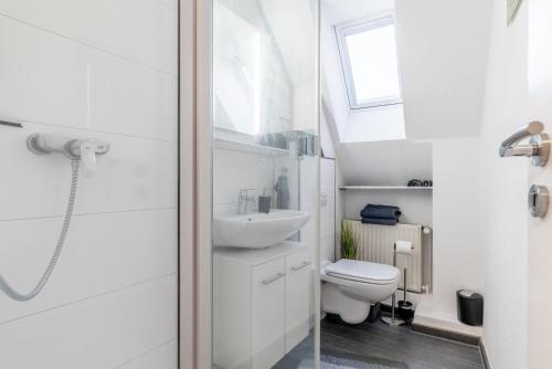 uma casa de banho branca com um WC e um lavatório em Private Apartment em Hanôver