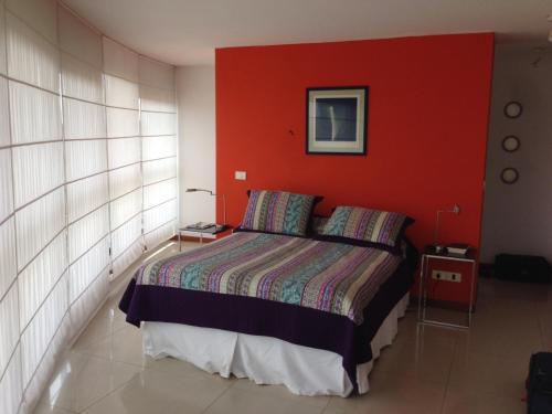 a bedroom with a bed with a red wall at Apartamento 907 in Punta del Este