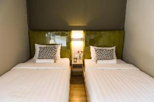two twin beds in a room with at V Varee Bangkok in Bangkok