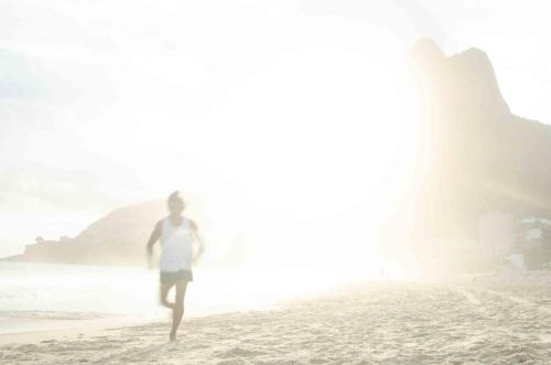 a person running on the beach near the ocean at JANEIRO Hotel in Rio de Janeiro