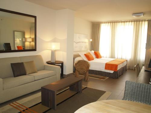 a hotel room with a bed and a couch at Eco Alcalá Suites in Madrid