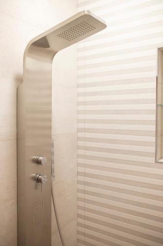 a shower with a shower head in a bathroom at Pupin Palace Apartments in Novi Sad