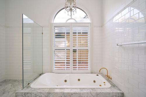 a bath tub in a bathroom with a window at Victoria's At Ewingsdale in Byron Bay