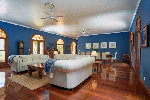 a living room with a white couch and blue walls at Victoria's At Ewingsdale in Byron Bay