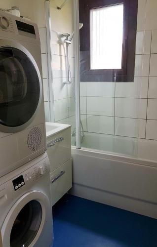 a bathroom with a washing machine next to a tub at Réf 541,Seignosse Océan, Appartement 3 pièces, proche de la plage et des commerces, 4 personnes in Seignosse